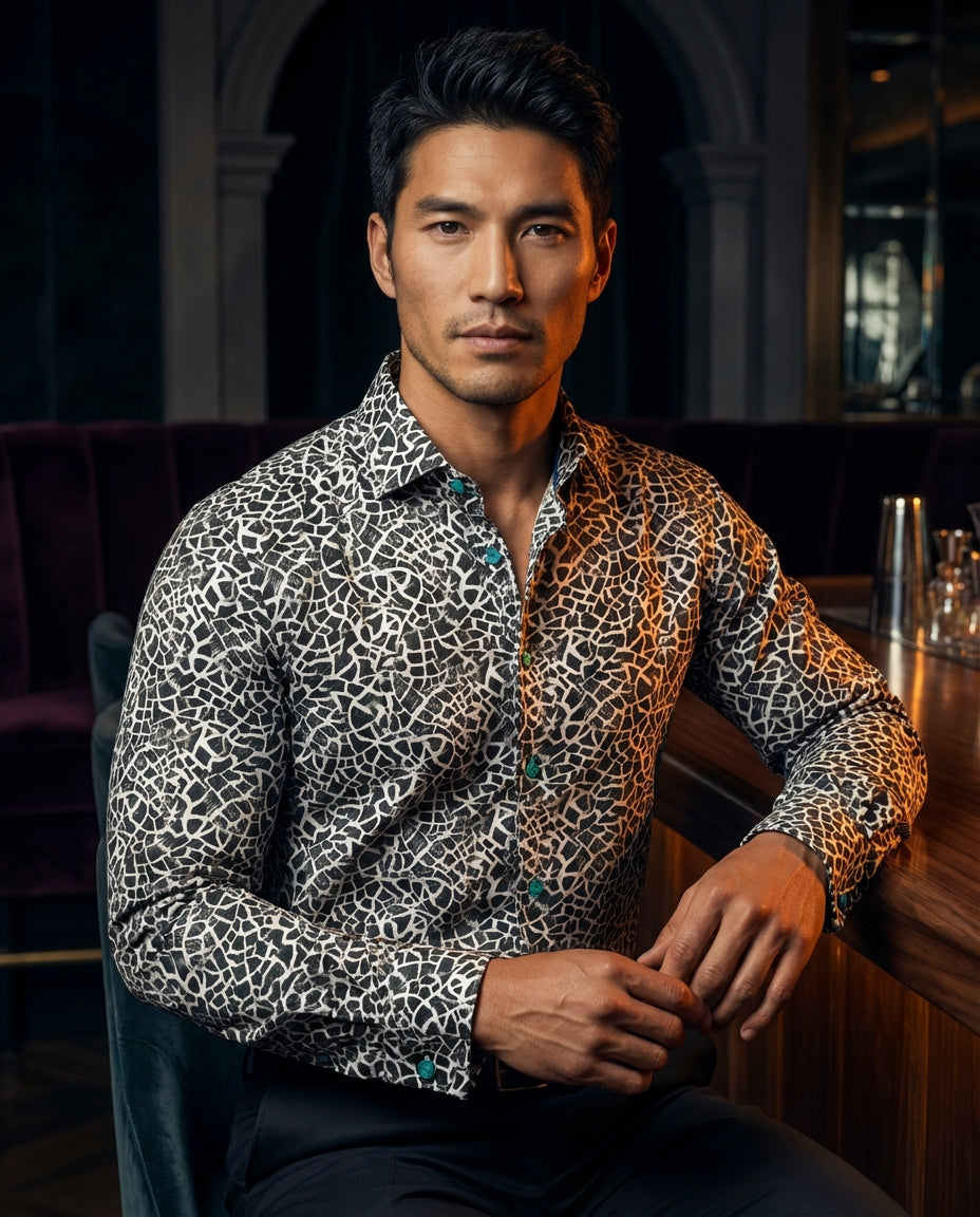 A bold men's long-sleeve dress shirt featuring a striking black and white geometric mosaic print. The design includes teal accent buttons and a refined spread collar, offering a contemporary Italian-inspired aesthetic perfect for making a sophisticated st