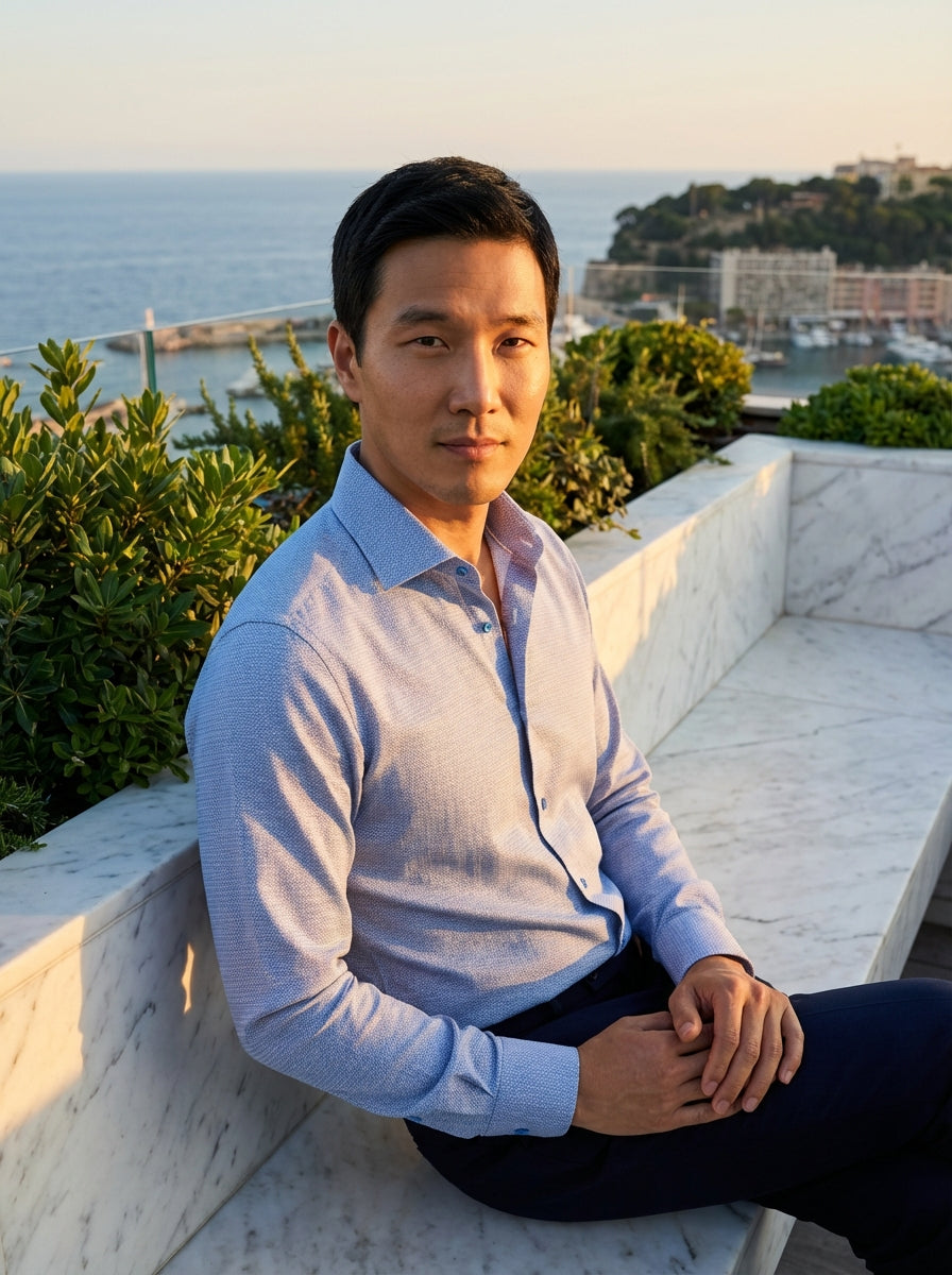 This Masutto men's dress shirt features a sophisticated light blue textured weave with a subtle geometric pattern. Designed with a classic spread collar and tonal buttons, this piece offers a refined, modern look suitable for both professional and smart-c