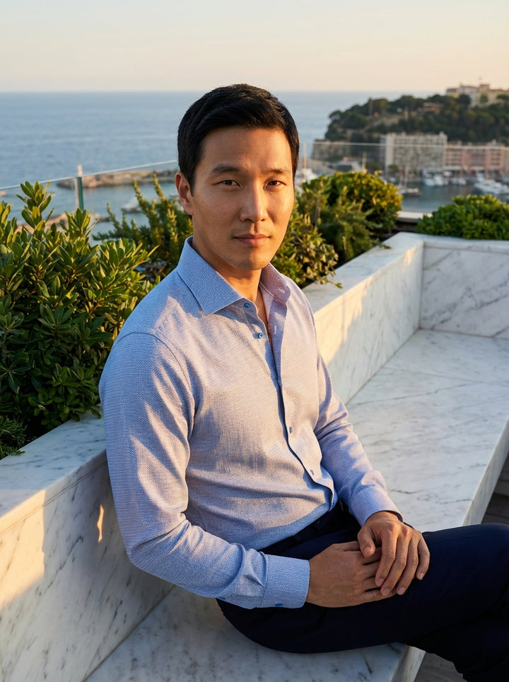 This Masutto men's dress shirt features a sophisticated light blue textured weave with a subtle geometric pattern. Designed with a classic spread collar and tonal buttons, this piece offers a refined, modern look suitable for both professional and smart-c