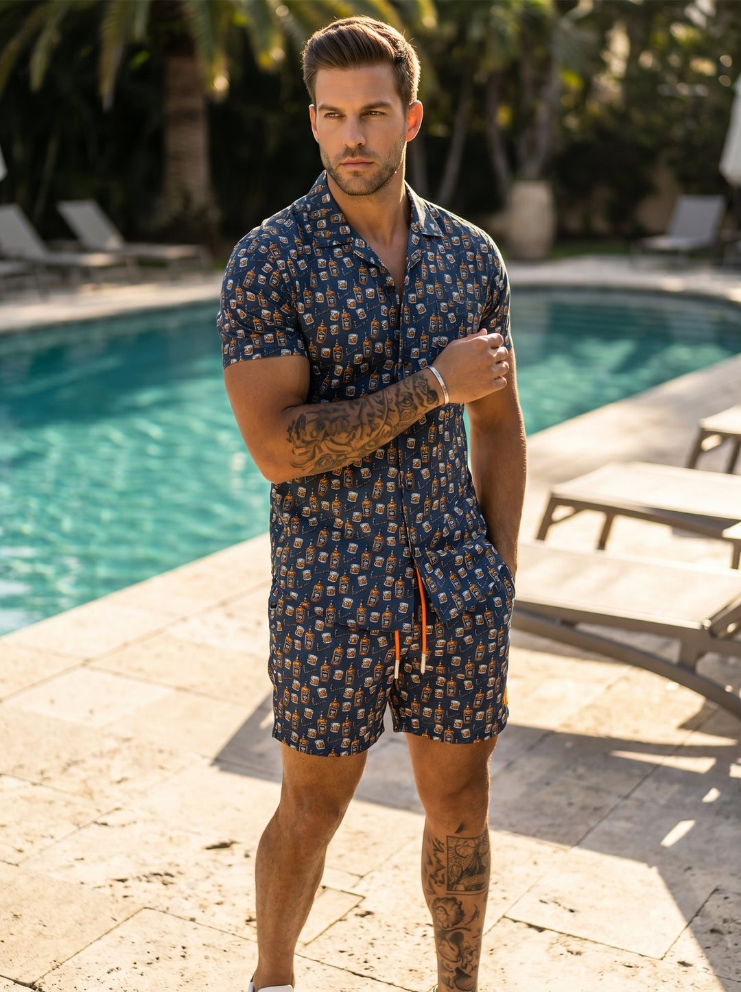 These navy blue swim trunks feature a playful all-over print of whiskey bottles and glasses. They are designed with a comfortable elastic waistband, vibrant orange drawstrings, and a mid-thigh cut, making them perfect for relaxed, stylish summer pool days
