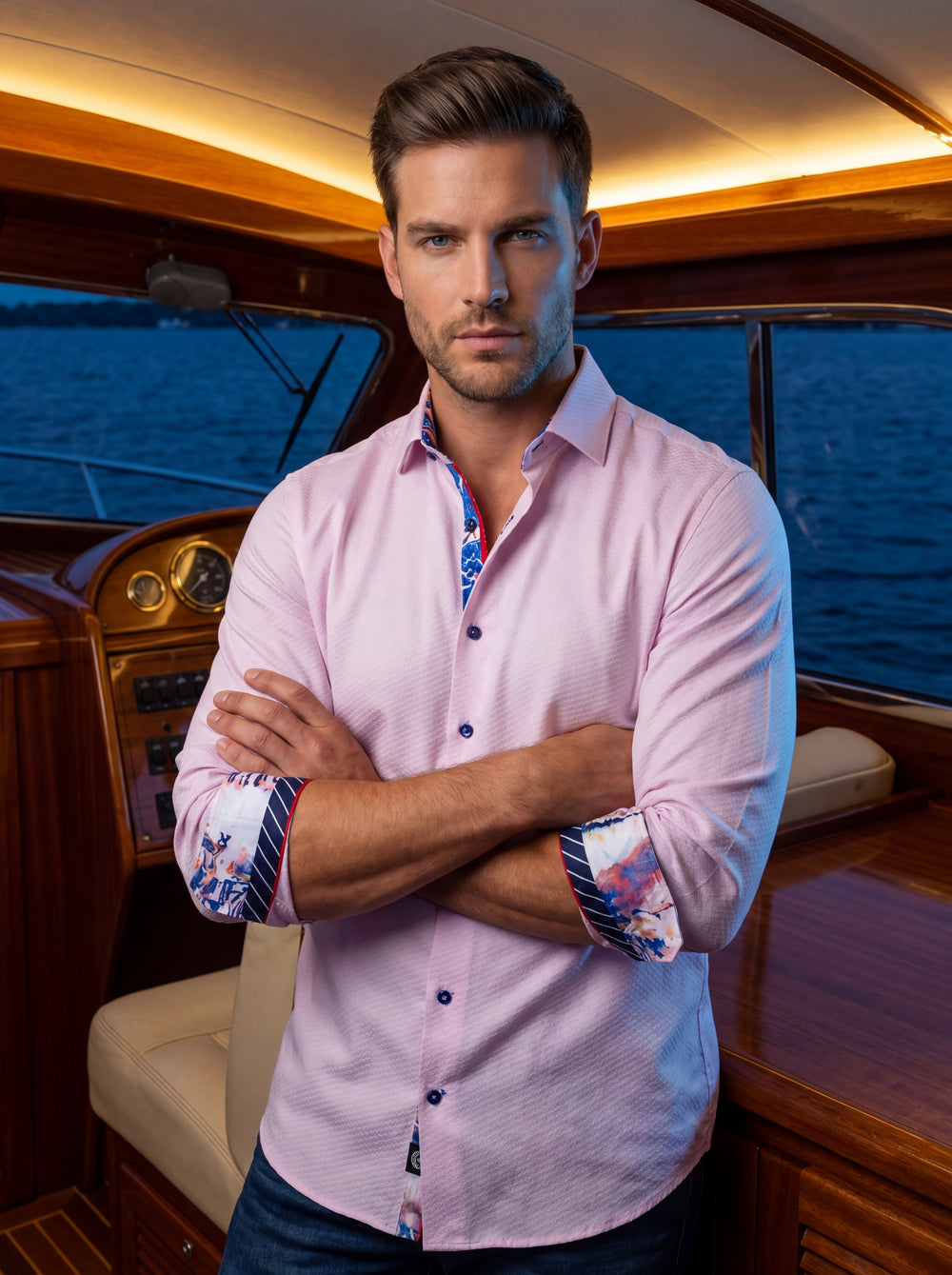 A sophisticated light pink button-down shirt featuring a textured jacquard weave. The design is elevated by vibrant contrast trim on the collar and cuffs, displaying blue and red nautical accents and colorful patterns, paired with navy blue buttons for mo