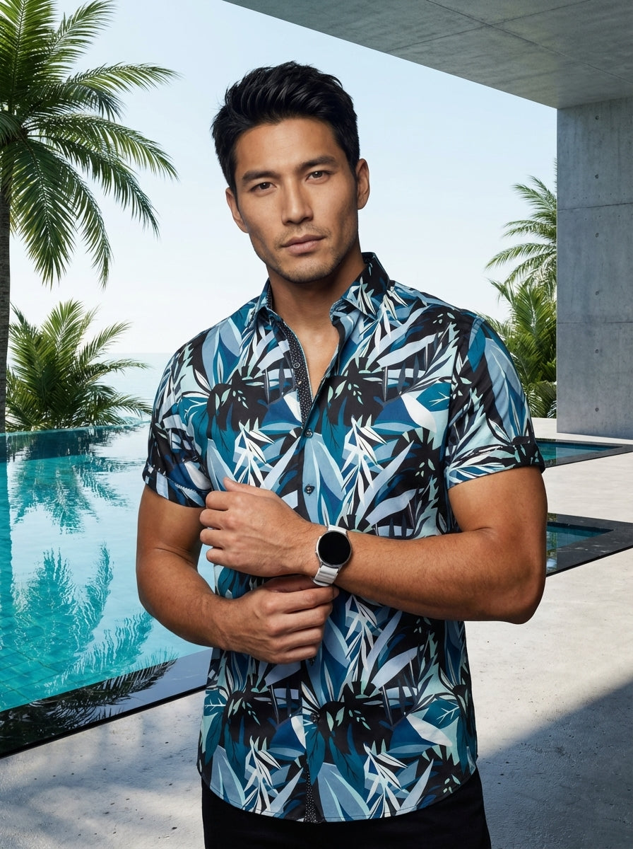This stylish short-sleeve button-down shirt features a vibrant blue and black tropical botanical print. Crafted with a tailored fit, it includes contrasting inner collar detailing and a curved hem, making it an essential piece for bold, modern summer ward