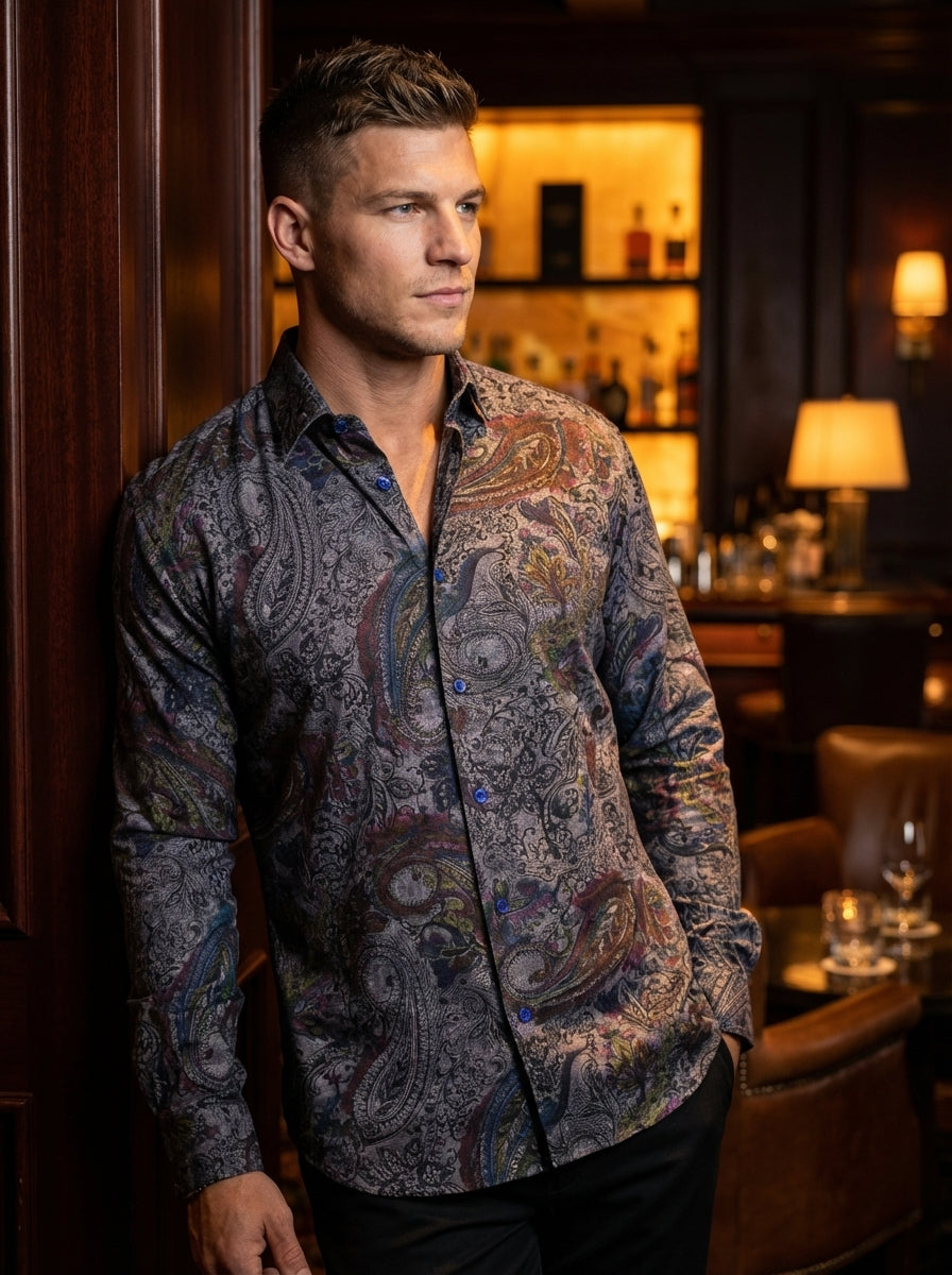 This sophisticated long-sleeve button-down shirt features an intricate paisley pattern in charcoal grey, accented by vibrant pops of purple, green, and blue. Crafted with a tailored fit, it includes contrasting blue buttons and a classic pointed collar fo