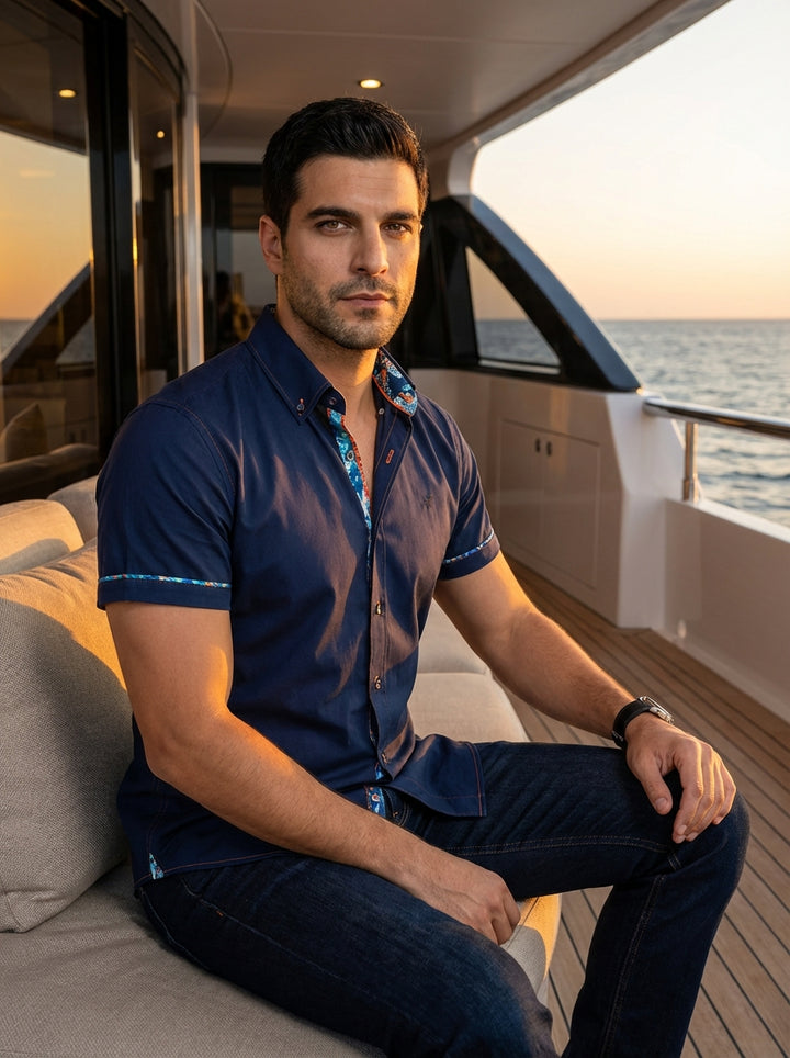 Elevate your casual wardrobe with this navy blue short-sleeve button-down shirt. Featuring a tailored fit, it boasts vibrant patterned trim on the inner collar and sleeve hems. The contrasting orange stitching adds a subtle, modern touch to this sophistic