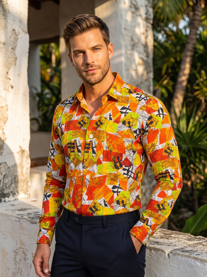 A vibrant long-sleeve button-down shirt featuring a bold, abstract geometric print in orange, yellow, and green. The piece includes a structured collar and white buttons, paired with dark navy trousers for a modern, artistic aesthetic.