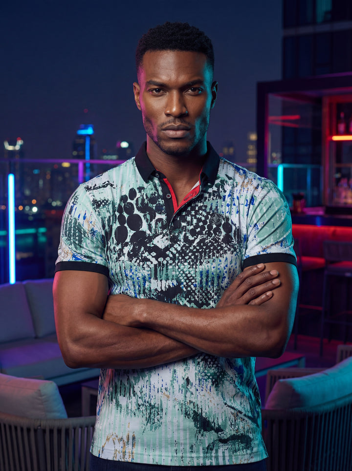 A bold men's short-sleeve polo shirt featuring an intricate, multi-tonal abstract print in shades of mint green, teal, and charcoal. The design includes a contrasting black collar and sleeve cuffs, accented by a distinctive red-lined inner placket for mod