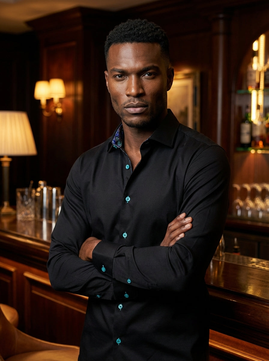 A sleek black button-down shirt by Masutto featuring vibrant turquoise buttons. The interior collar is lined with a colorful tropical palm leaf pattern, offering a hidden dash of personality and flair for a modern, sophisticated look that stands out.