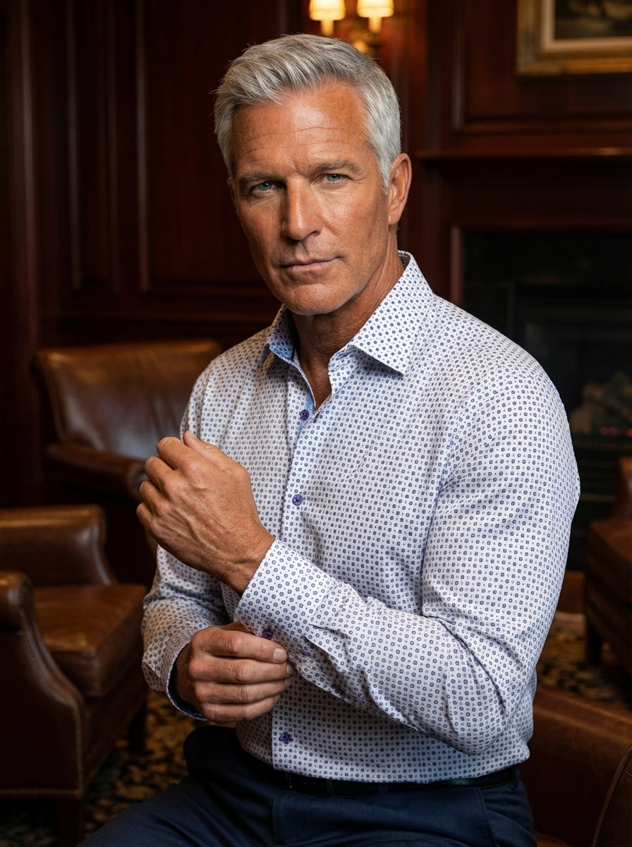 This men's long-sleeve dress shirt features a crisp white base with a sophisticated blue geometric diamond pattern. It is designed with a modern tailored fit, contrasting navy blue interior collar details, and purple buttons for a unique, polished aesthet