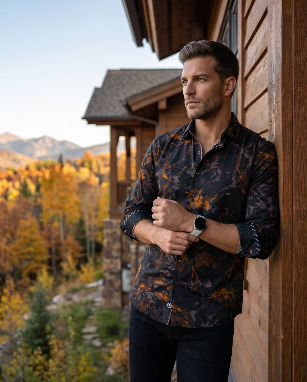 A sophisticated long-sleeve button-down shirt featuring a dynamic abstract print in shades of bronze, charcoal, and black. The garment includes unique contrast cuff detailing with white diagonal stitching and a tailored fit, perfect for making a bold even