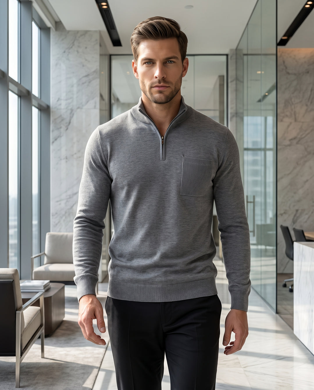 This sophisticated grey quarter-zip sweater features a refined mock neck and a vertical ribbed chest pocket. Crafted from a soft, lightweight knit, it offers a tailored fit with ribbed cuffs and hem, perfectly blending comfort with a polished aesthetic.