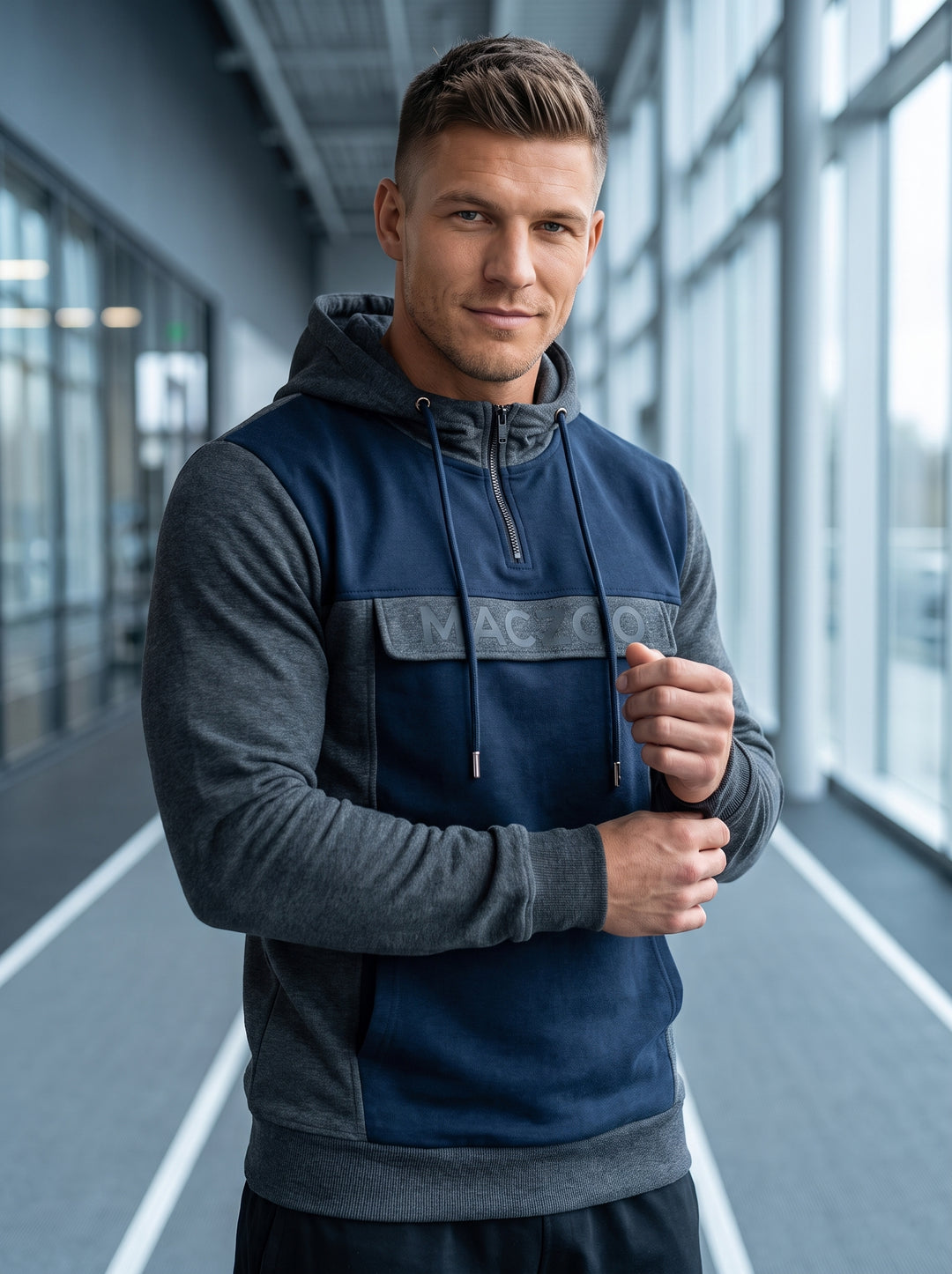 This premium athletic hoodie features a modern color-blocked design in charcoal grey and navy blue. Crafted with a quarter-zip neckline and adjustable drawstring hood, it includes a branded chest panel and ribbed cuffs for a functional yet stylish athleti
