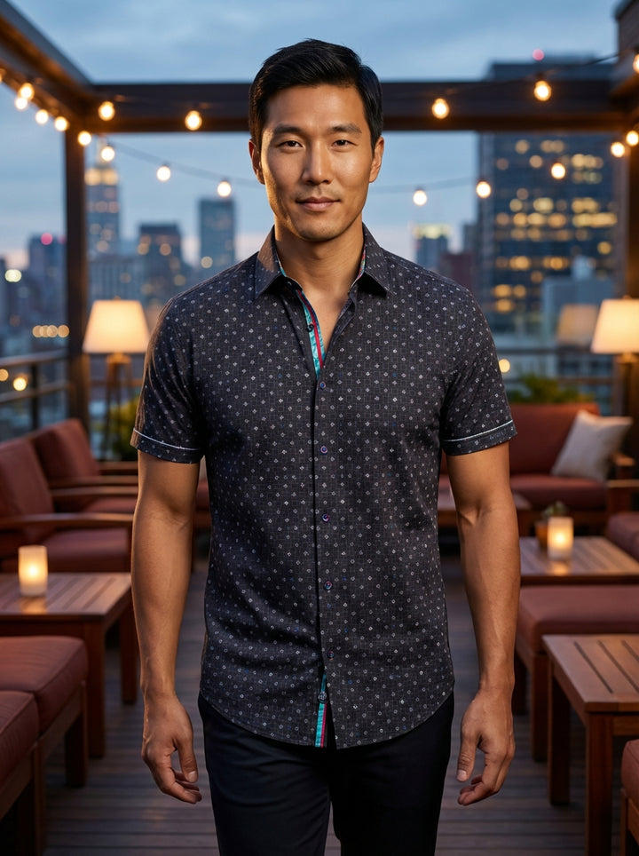 Elevate your casual attire with this sophisticated short-sleeve button-down shirt. Featuring a refined geometric micro-print on deep charcoal fabric, it boasts vibrant multi-colored interior placket detailing and contrast stitching, offering a modern tail