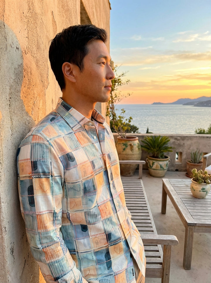 This Masutto button-down shirt features a captivating patchwork-inspired print in a serene palette of seafoam blue, soft orange, and cream. The watercolor-style checks are accented by intricate geometric linework and contrast stitching, offering a modern,