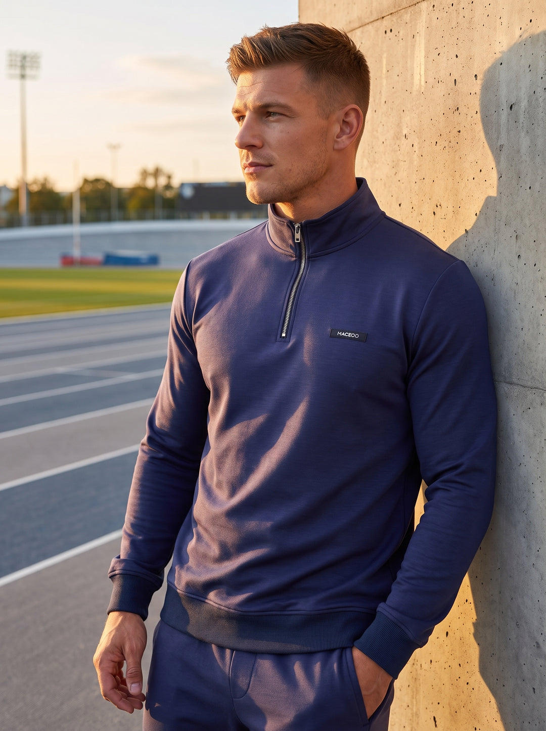This navy blue quarter-zip pullover features a high collar and sleek metallic zipper. Crafted from a comfortable jersey blend with ribbed cuffs and hem, it includes a subtle chest logo, offering a refined yet sporty aesthetic for everyday casual wear.