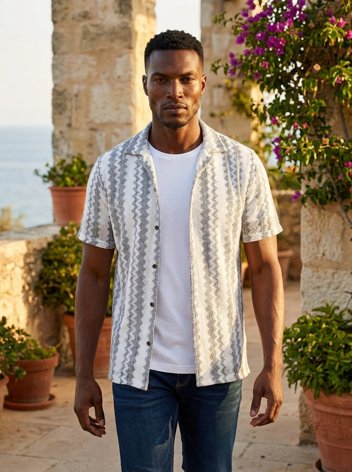 Elevate your casual wardrobe with this stylish short-sleeve button-down shirt featuring a textured zig-zag pattern in monochromatic tones. Layered over a classic white tee, its lightweight fabric and relaxed fit offer a sophisticated yet effortless look f