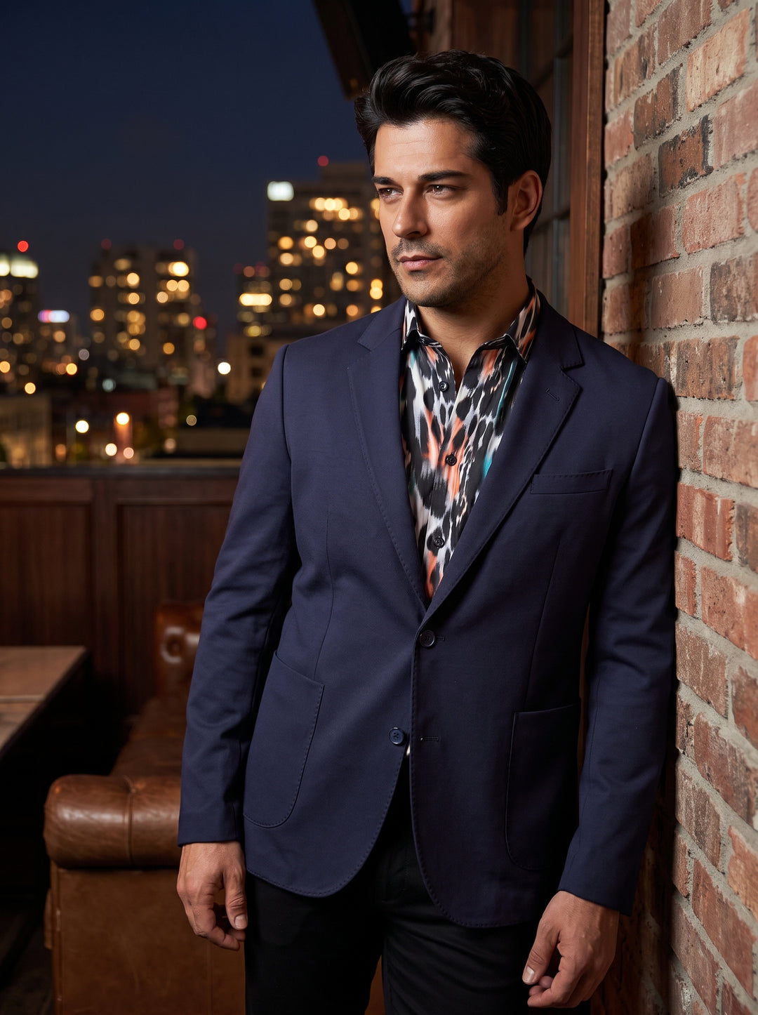 This tailored navy blue blazer features a modern two-button closure and classic notch lapels. It is constructed with prominent patch pockets and structured shoulders for a sophisticated silhouette. Paired here with a bold, abstract-print button-down for a