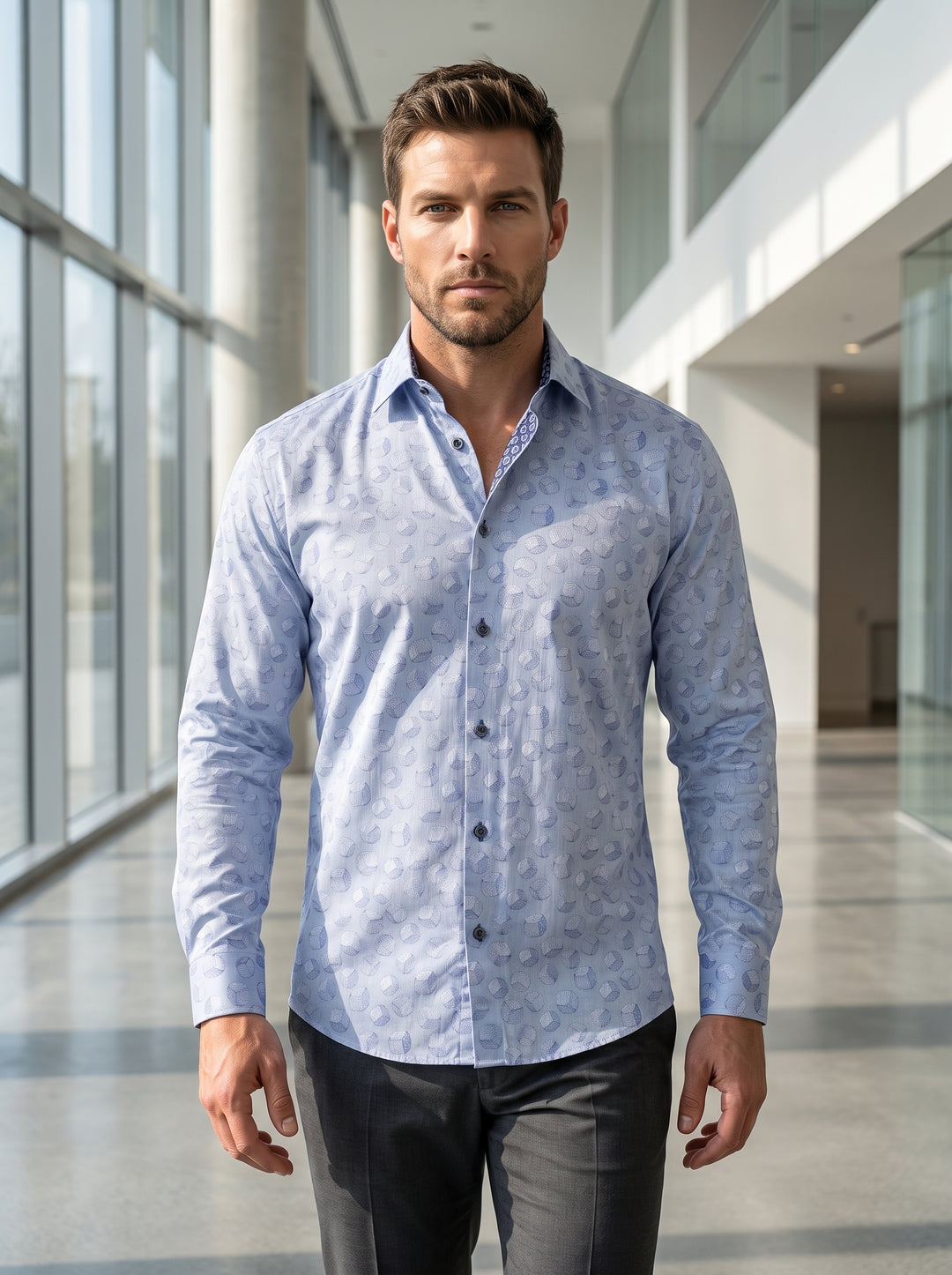 A sophisticated light blue long-sleeved button-down shirt featuring an intricate all-over geometric cube pattern. Crafted with a tailored fit, it includes a contrasting patterned inner collar and dark buttons for a refined, modern look suitable for upscal