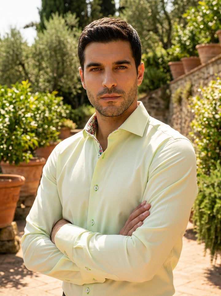 This Masutto designer dress shirt in a refreshing pale lime hue features a crisp spread collar and a vibrant floral-print lining. Crafted for elegance, it includes contrasting lime green stitching on the buttonholes and polished white buttons for modern s