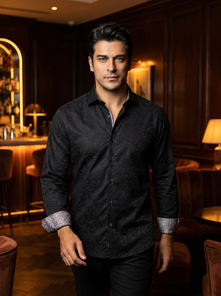 This Masutto luxury black dress shirt features an intricate tonal floral damask pattern. The design is elevated by contrasting patterned inner collar lining and cuffs, paired with distinctive purple-stitched buttons for a sophisticated, modern Italian aes