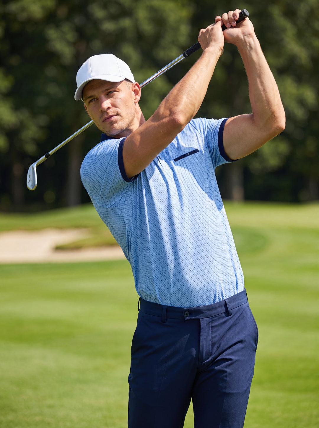 This light blue men's polo shirt features a subtle geometric micro-print and contrasting navy blue accents on the collar, sleeve cuffs, and chest pocket welt. Crafted for a modern fit, it includes a three-button placket and classic white collar tipping.