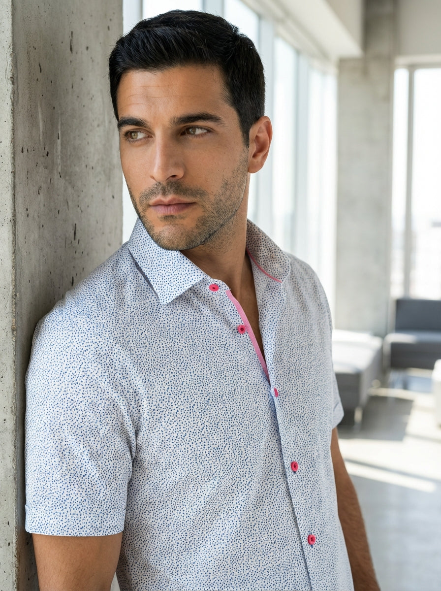 This Masutto men's shor-sleeve shirt features a crisp white base adorned with a detailed blue micro-ditsy print. The sophisticated design is accented by vibrant pink buttons and a matching inner collar trim, offering a contemporary twist on classic tailor