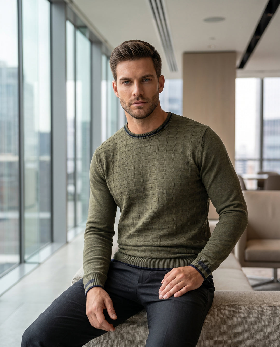 This men's olive green crewneck sweater features a sophisticated textured grid pattern throughout the torso. Designed with navy blue contrast tipping on the collar, cuffs, and hem, it offers a refined slim fit suitable for layering or standalone wear.
