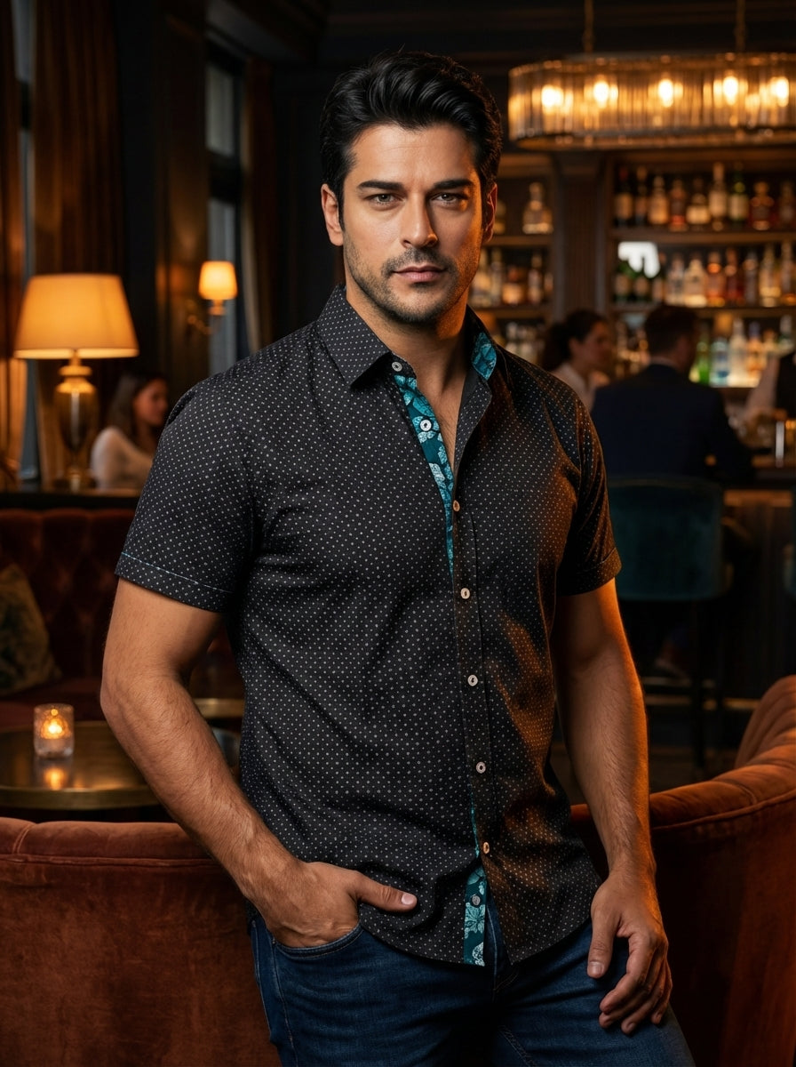 This tailored short-sleeved button-down features a sophisticated micro-pattern of geometric dots over a deep black base. The inner collar and placket reveal a contrasting teal floral lining, adding a modern twist to a classic silhouette perfect for evenin