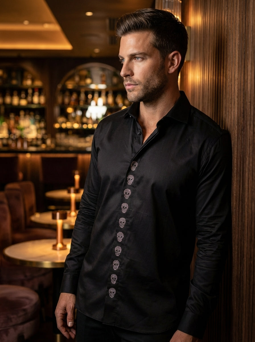 This sleek black long-sleeve button-down shirt features a tailored fit and a unique design element. A vertical row of crystal-embellished skull motifs runs down the front placket, adding an edgy, rebellious touch to a classic, sophisticated silhouette for