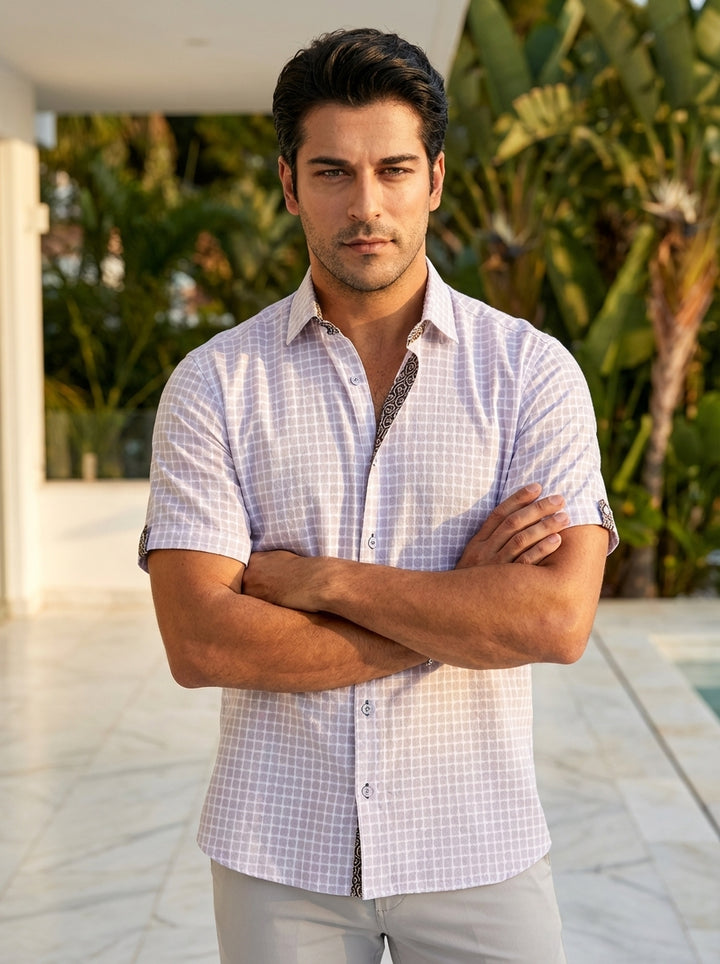 This men's short-sleeve button-down shirt features a light lavender and white geometric grid pattern with a textured finish. Intricate contrast trim detailing on the inner collar and sleeve cuffs adds a sophisticated touch to this modern, breathable cotto