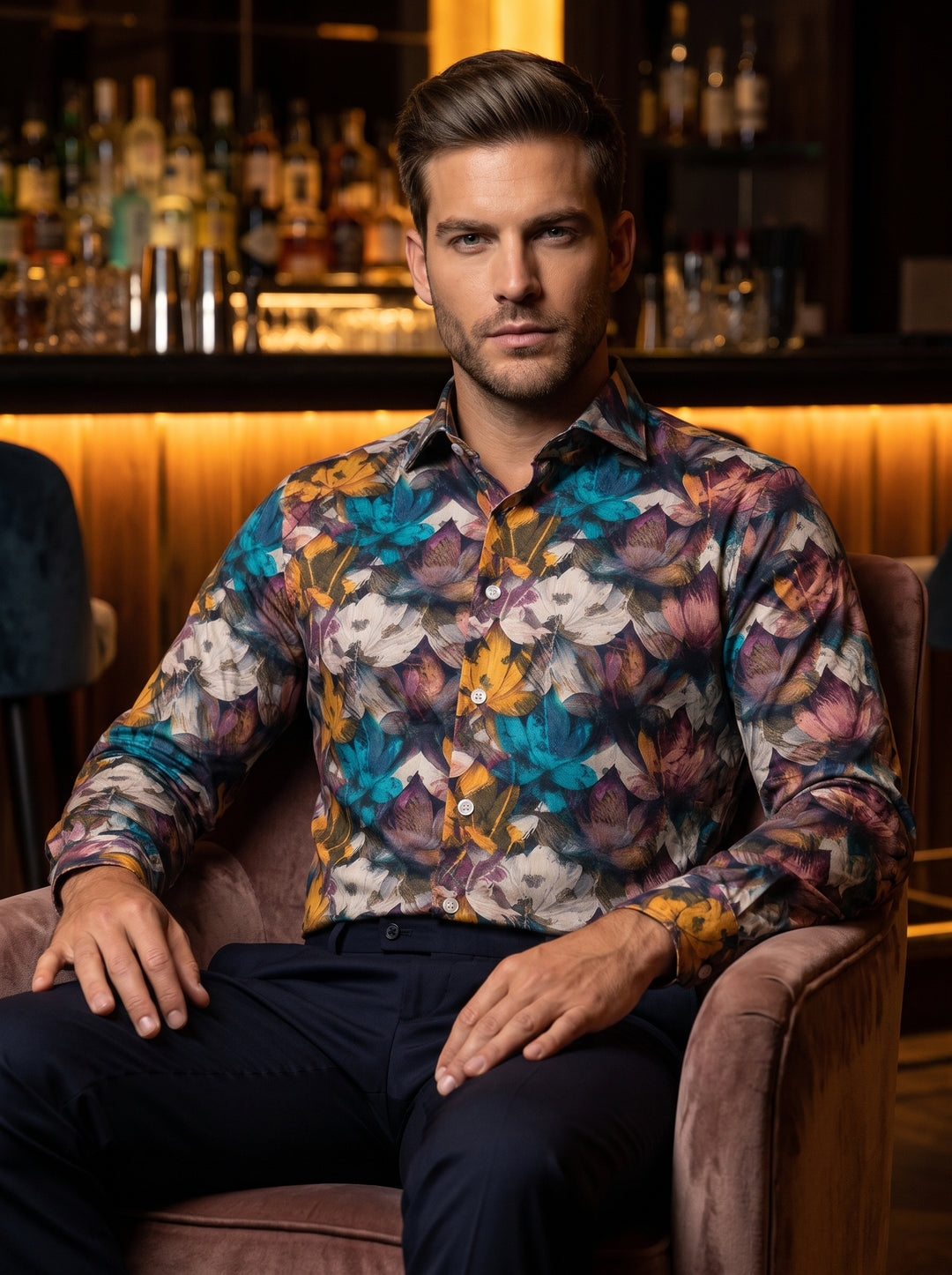 A long-sleeved button-down shirt featuring a vibrant, all-over floral pattern in shades of teal, mustard, plum, and white. This slim-fit garment offers a sophisticated spread collar and polished buttons, perfect for statement-driven semi-formal or upscale