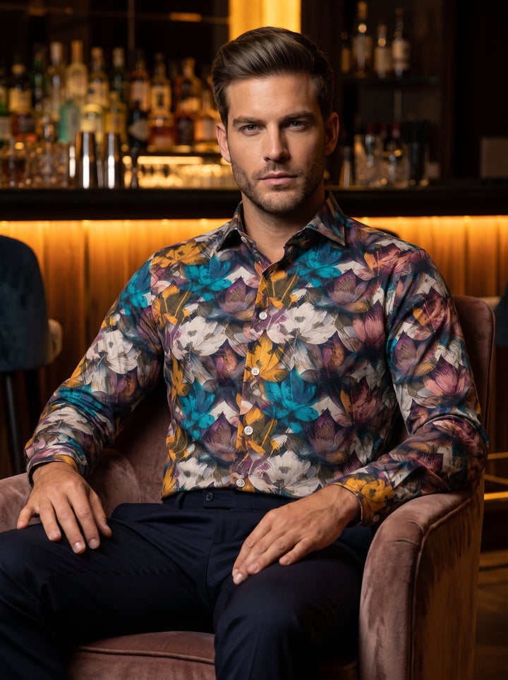 A long-sleeved button-down shirt featuring a vibrant, all-over floral pattern in shades of teal, mustard, plum, and white. This slim-fit garment offers a sophisticated spread collar and polished buttons, perfect for statement-driven semi-formal or upscale