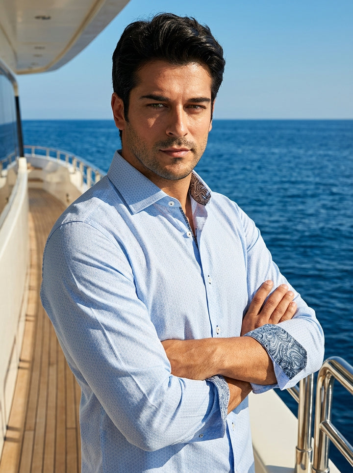 This light blue Masutto dress shirt features a sophisticated geometric micro-pattern and a classic spread collar. The design is elevated by contrasting paisley trim inside the collar and cuffs, finished with elegant pearlescent buttons and a tailored, mod