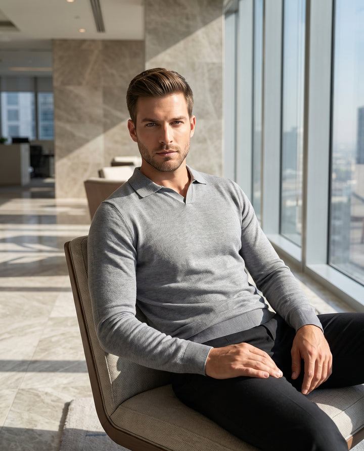 A refined grey long-sleeved polo sweater crafted from a fine-gauge knit. It features a modern Johnny collar, ribbed cuffs, and a ribbed hem for a tailored fit. This versatile piece offers a polished look for transitional weather styling.