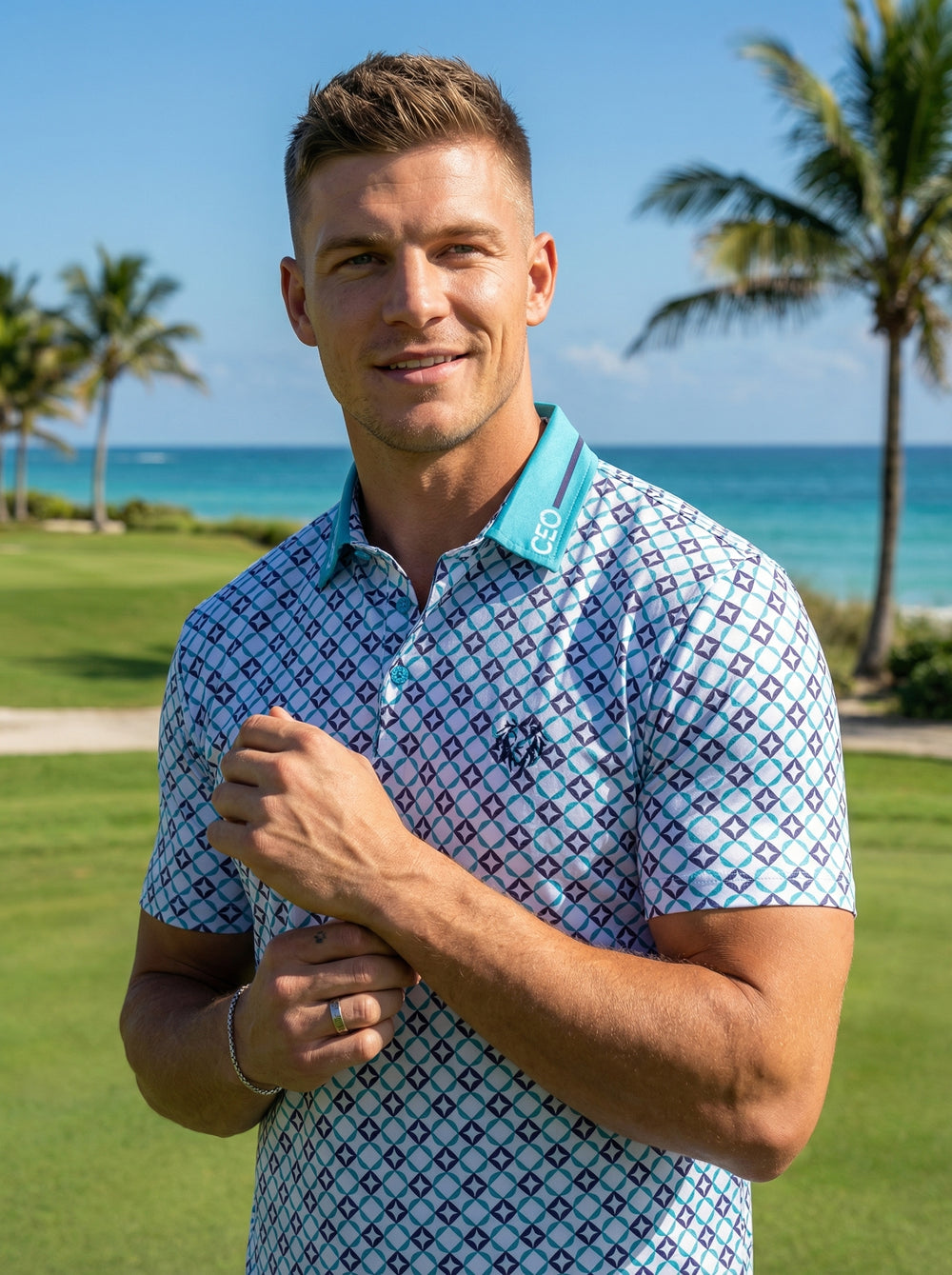 This stylish short-sleeve polo features a vibrant geometric diamond print in shades of blue and teal. Designed with a contrast teal collar and a modern athletic fit, it offers a sophisticated look for active or leisure activities in the sun.