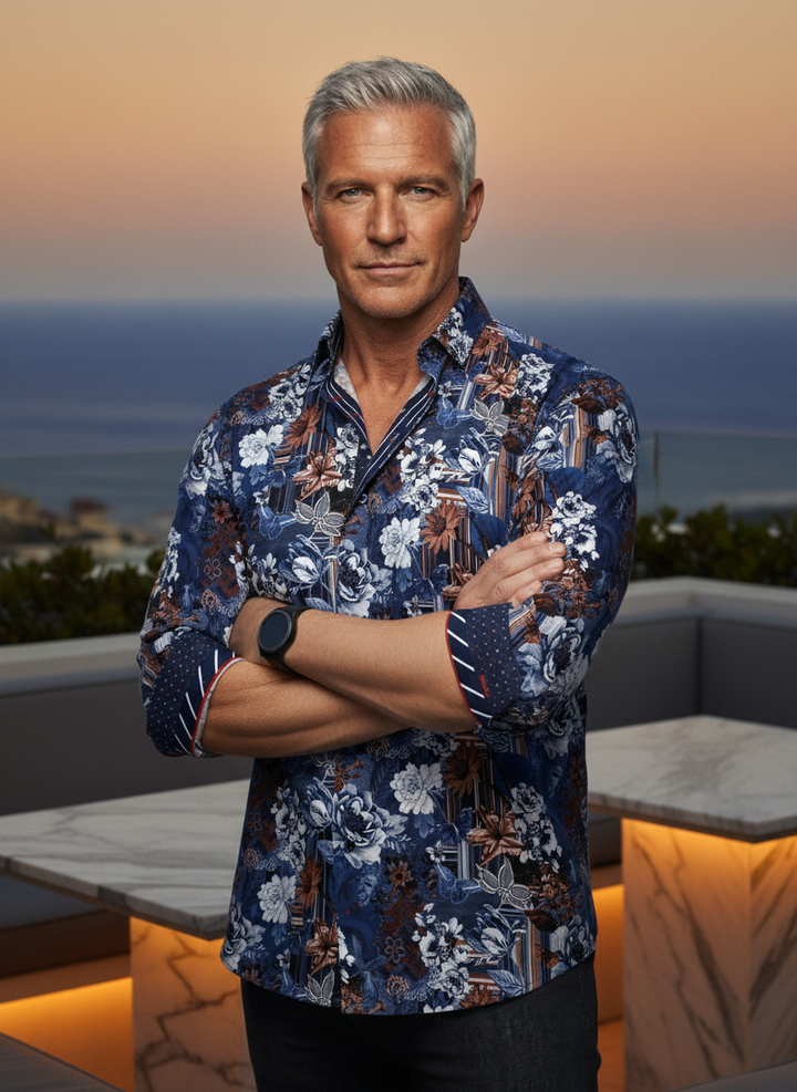 This statement button-down features a rich navy and copper floral tapestry interwoven with modern stripes. Meticulously crafted with contrast red piping and patterned cuff accents, it offers a bold, sophisticated silhouette for the discerning modern man.