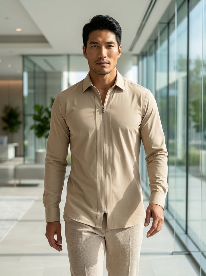 This modern men's zip-front dress shirt features a sophisticated tan hue and a streamlined hidden zipper placket. Crafted from a smooth, stretch-blend fabric, it offers a contemporary slim fit with a traditional pointed collar and clean-finish barrel cuff