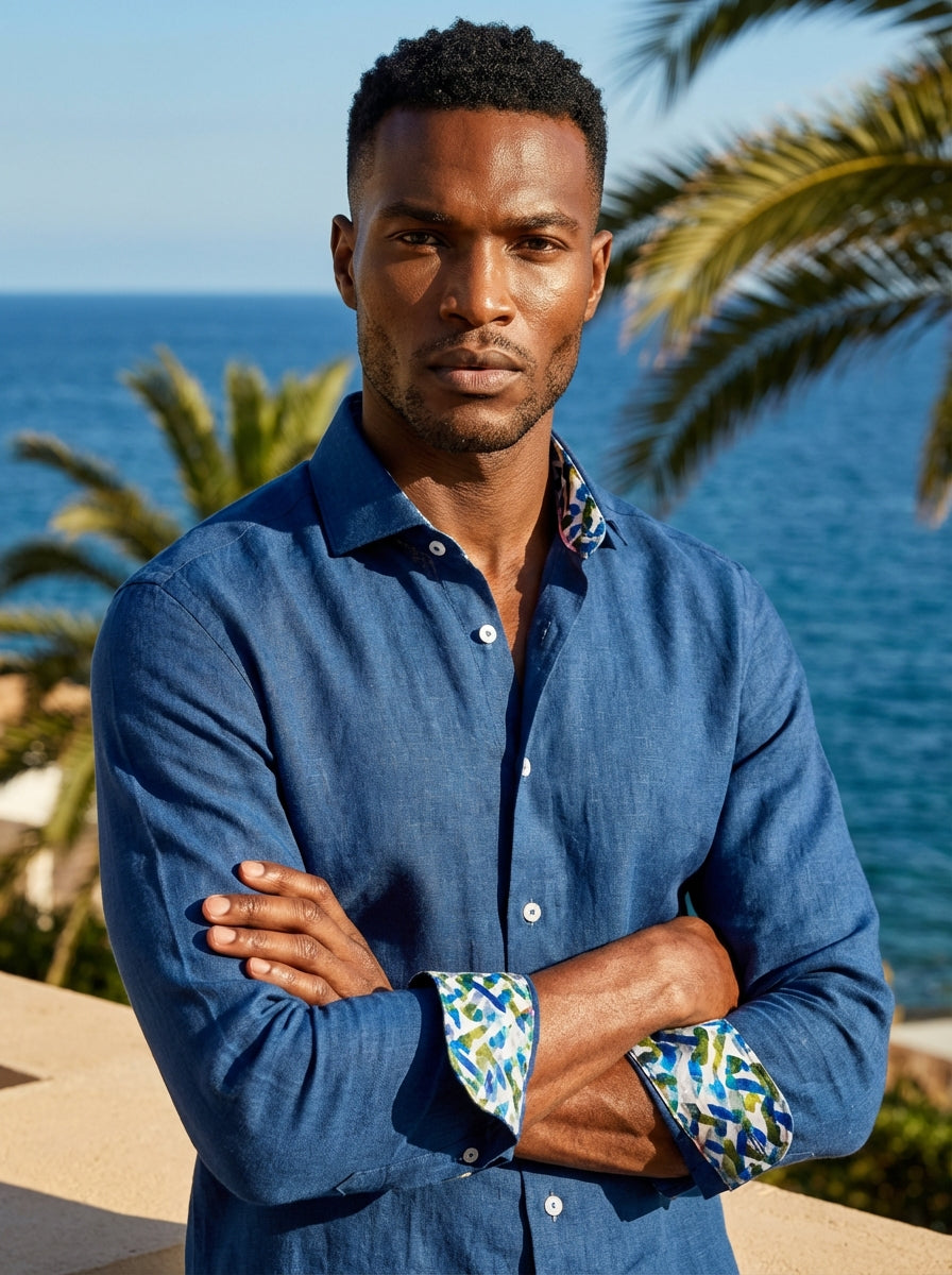 This Masutto linen-blend button-down shirt features a rich indigo blue hue with a sophisticated textured finish. The design is elevated by a vibrant, multi-colored abstract print lining the collar and cuffs, complemented by contrasting white buttons for a