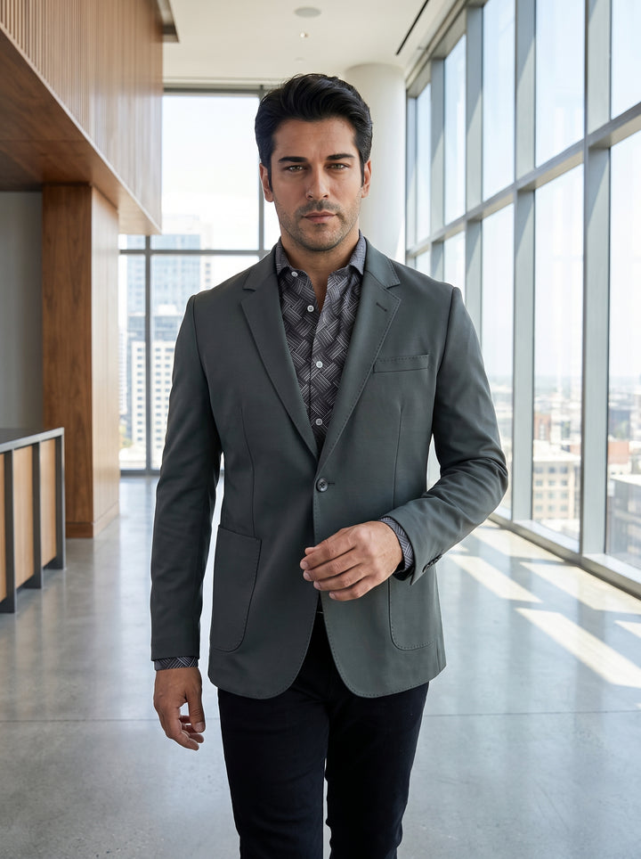 This sophisticated ensemble features a tailored charcoal grey blazer with classic notch lapels and functional patch pockets. It is layered over a charcoal patterned button-down shirt, showcasing a modern geometric print for a sharp, textured, and contempo