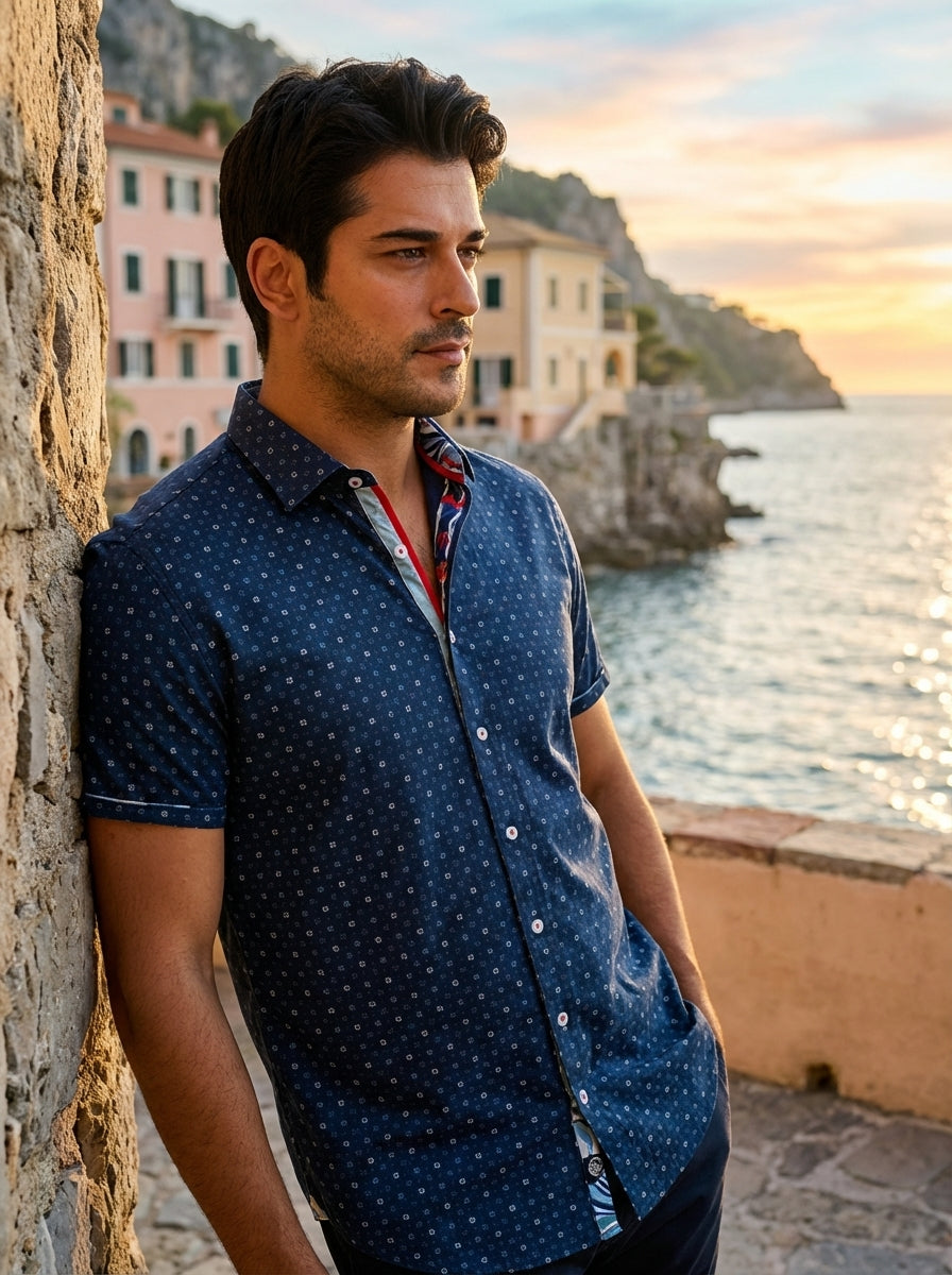 This navy blue short-sleeved button-down shirt features a sophisticated all-over geometric floral micro-print. Detailed with contrasting red and white inner placket accents and white buttons, it offers a refined slim fit perfect for making a stylish impre