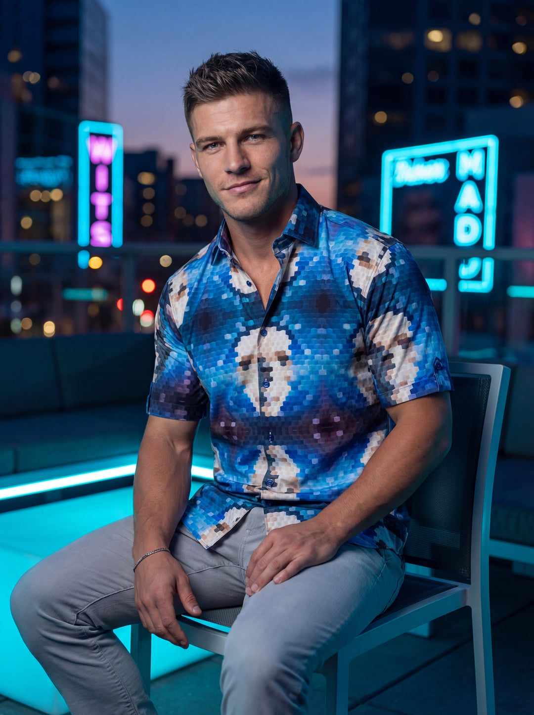 This men's short-sleeve button-down shirt features a striking blue and white pixelated digital print. The geometric, kaleidoscopic pattern creates a modern aesthetic, while the slim fit and structured collar ensure a polished silhouette suitable for upsca