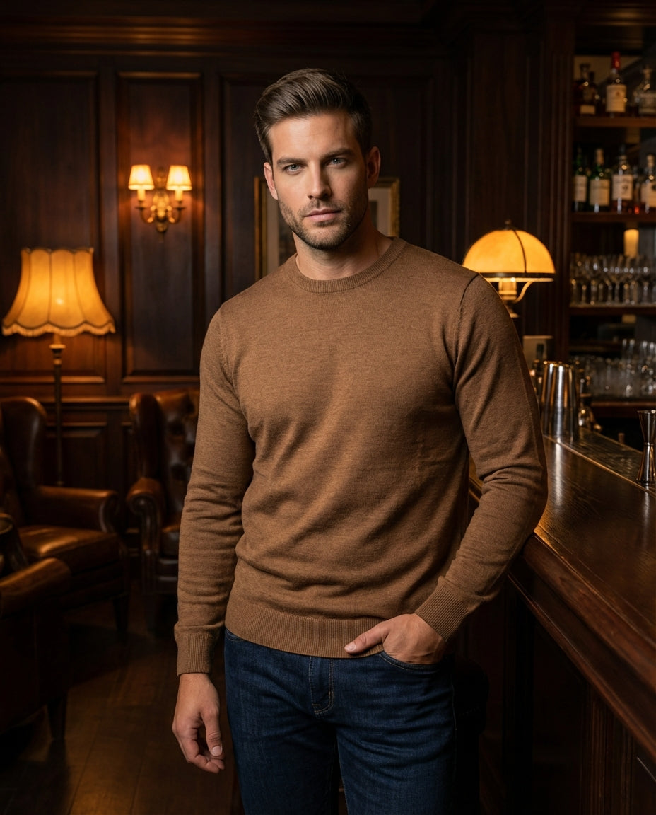 This classic crewneck sweater in a warm tobacco brown features a fine-gauge knit for a sleek, streamlined fit. The garment includes ribbed cuffs and a matching ribbed hem, making it an essential layering piece for a modern, sophisticated male wardrobe.