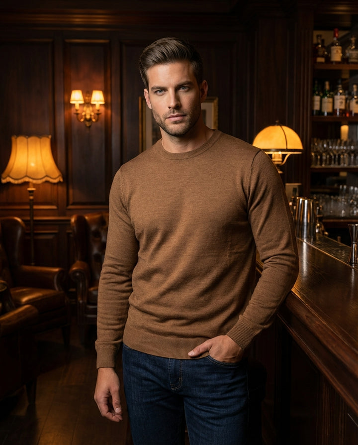 This classic crewneck sweater in a warm tobacco brown features a fine-gauge knit for a sleek, streamlined fit. The garment includes ribbed cuffs and a matching ribbed hem, making it an essential layering piece for a modern, sophisticated male wardrobe.