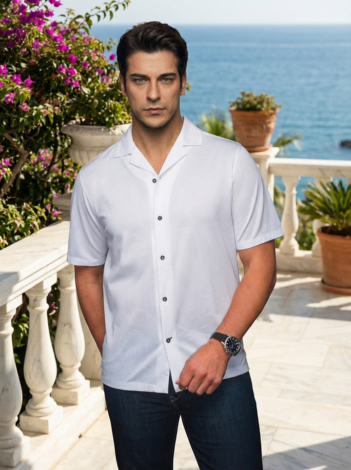 This crisp white short-sleeve button-up features a refined Cuban collar and a subtle textured pattern for an elevated aesthetic. Crafted with high-quality fabric and contrasting dark buttons, it offers a versatile, modern fit perfect for casual yet sophis