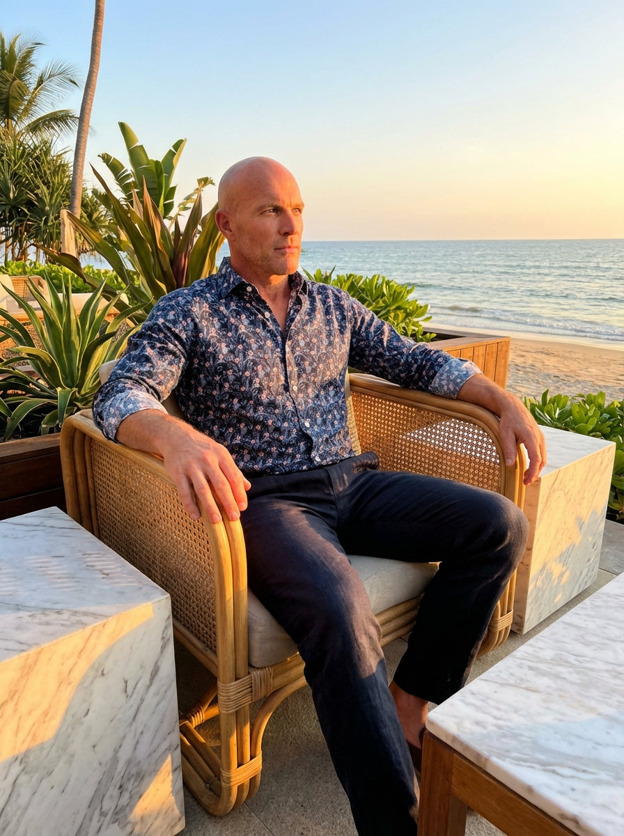 This premium Masutto button-down shirt features a sophisticated navy base adorned with a lush tropical palm leaf and floral motif. Crafted for elegance and comfort, it includes a sharp collar and contrasting white buttons, perfect for upscale summer eveni