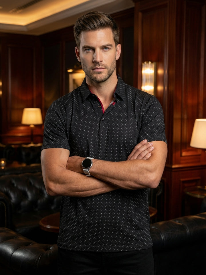 This sophisticated black short-sleeve polo features a delicate white micro-dot pattern, adding texture and depth. Crafted with a classic collar and subtle red interior detailing, it offers a refined slim fit that seamlessly transitions from professional s