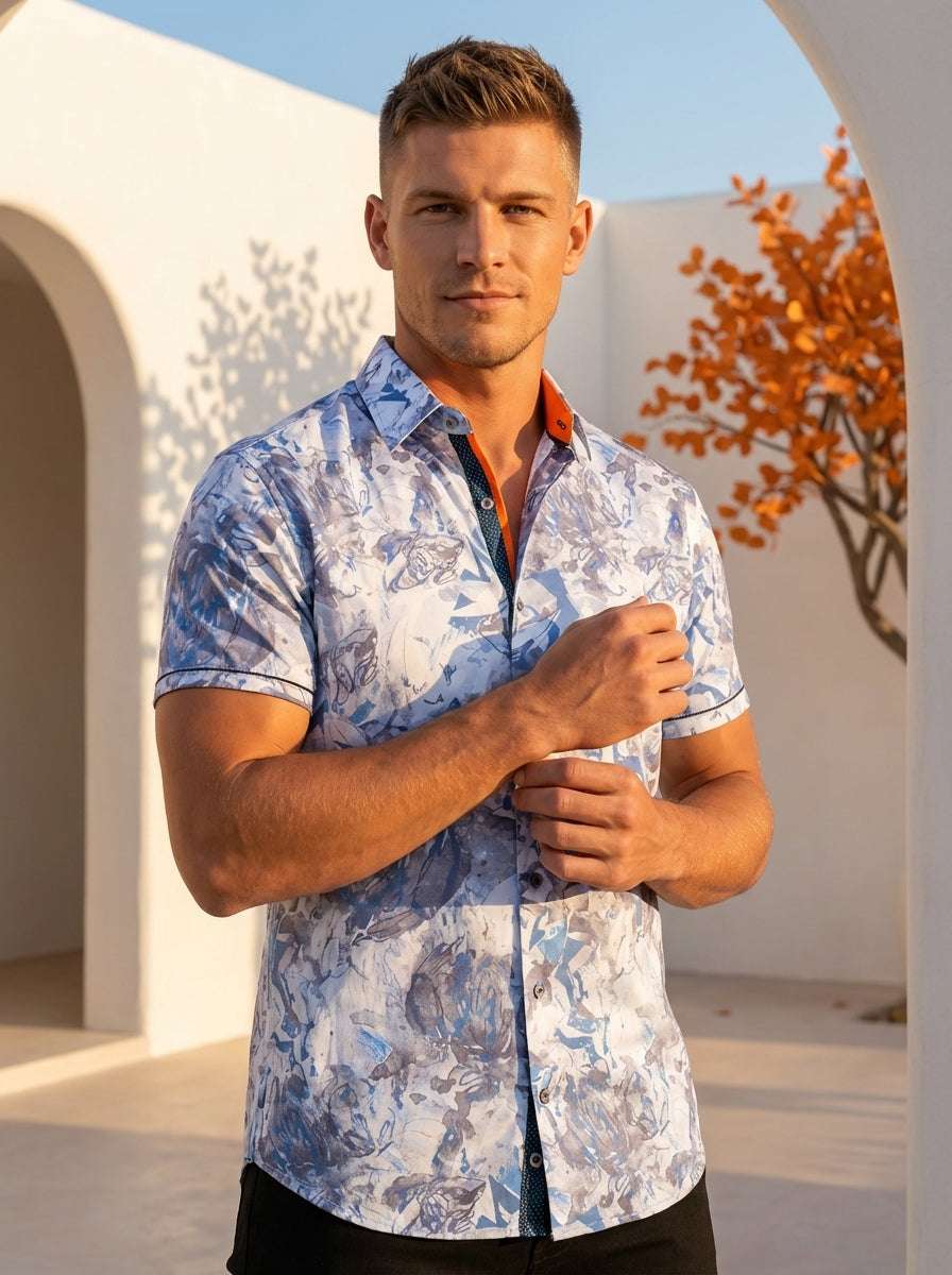 This stylish short-sleeve button-down shirt features a dynamic blue and grey abstract floral print on a crisp white background. Accented with contrast piping and a vibrant orange inner collar stand, this tailored piece offers a sophisticated take on casua