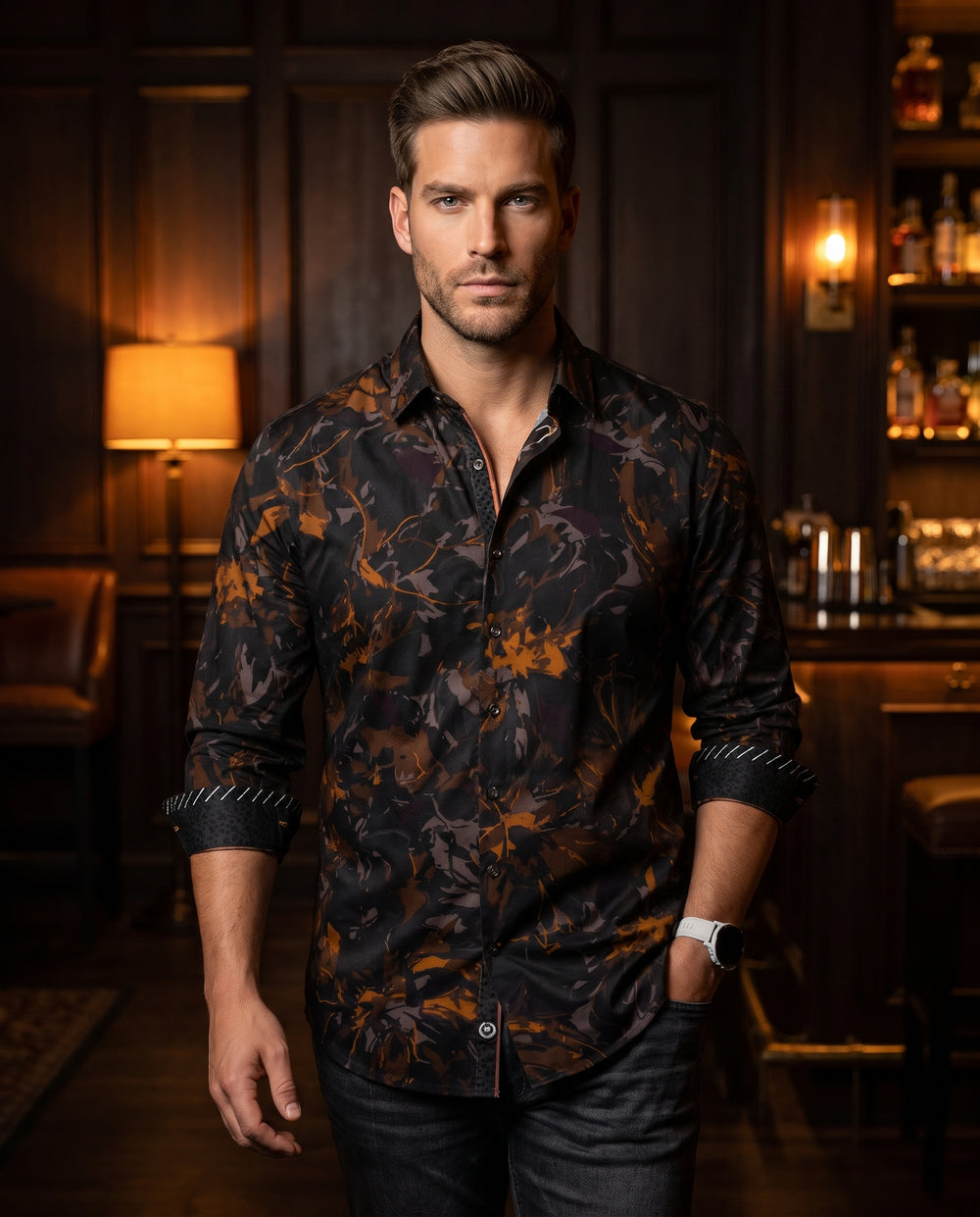 A sophisticated long-sleeve button-down shirt featuring a dynamic abstract print in shades of bronze, charcoal, and black. The garment includes unique contrast cuff detailing with white diagonal stitching and a tailored fit, perfect for making a bold even