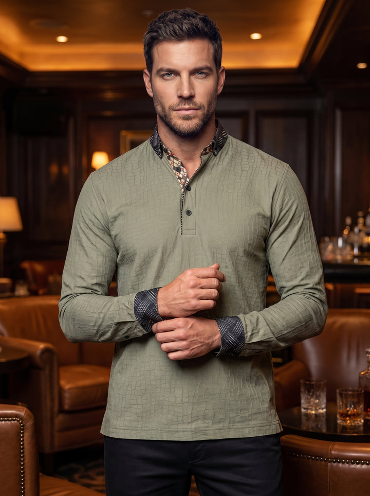 This sage green long-sleeve polo features a subtle embossed crocodile texture and a three-button placket. Contrast patterned trim decorates the inner collar, outer collar, and cuffs, adding a sophisticated, modern detail to this tailored, versatile knit s
