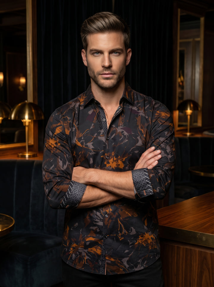 A sophisticated men's long-sleeve button-down shirt featuring a dark charcoal base with an abstract floral print in burnt orange and muted grey. The garment includes unique contrast-patterned cuffs and a tailored fit, perfect for making a bold style state