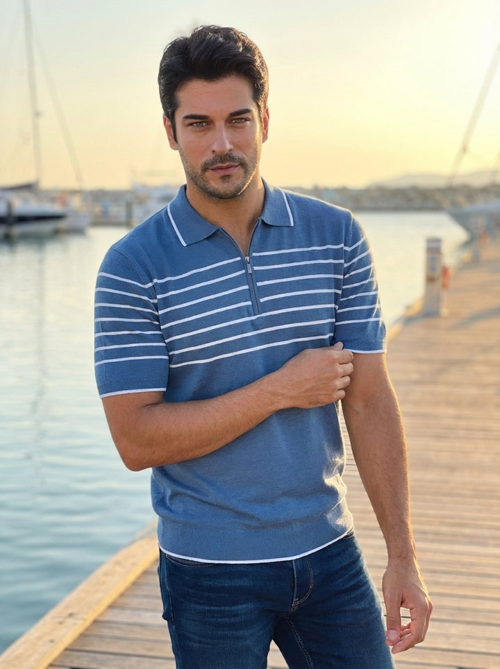 This sophisticated men's short-sleeve knit polo features a serene blue hue accented by crisp horizontal white stripes across the chest. The design includes a modern quarter-zip neckline with a contrasting white collar and ribbed cuffs for a refined, tailo